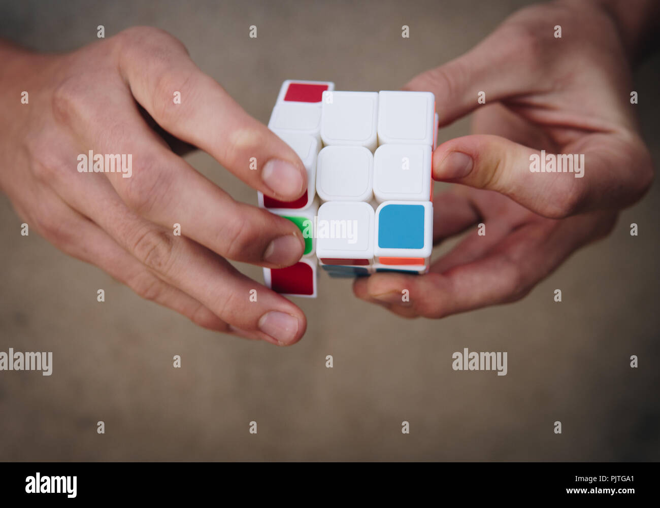 Nahaufnahme der Hände, die versuchen, die Rubik's Cube zu lösen Stockfoto