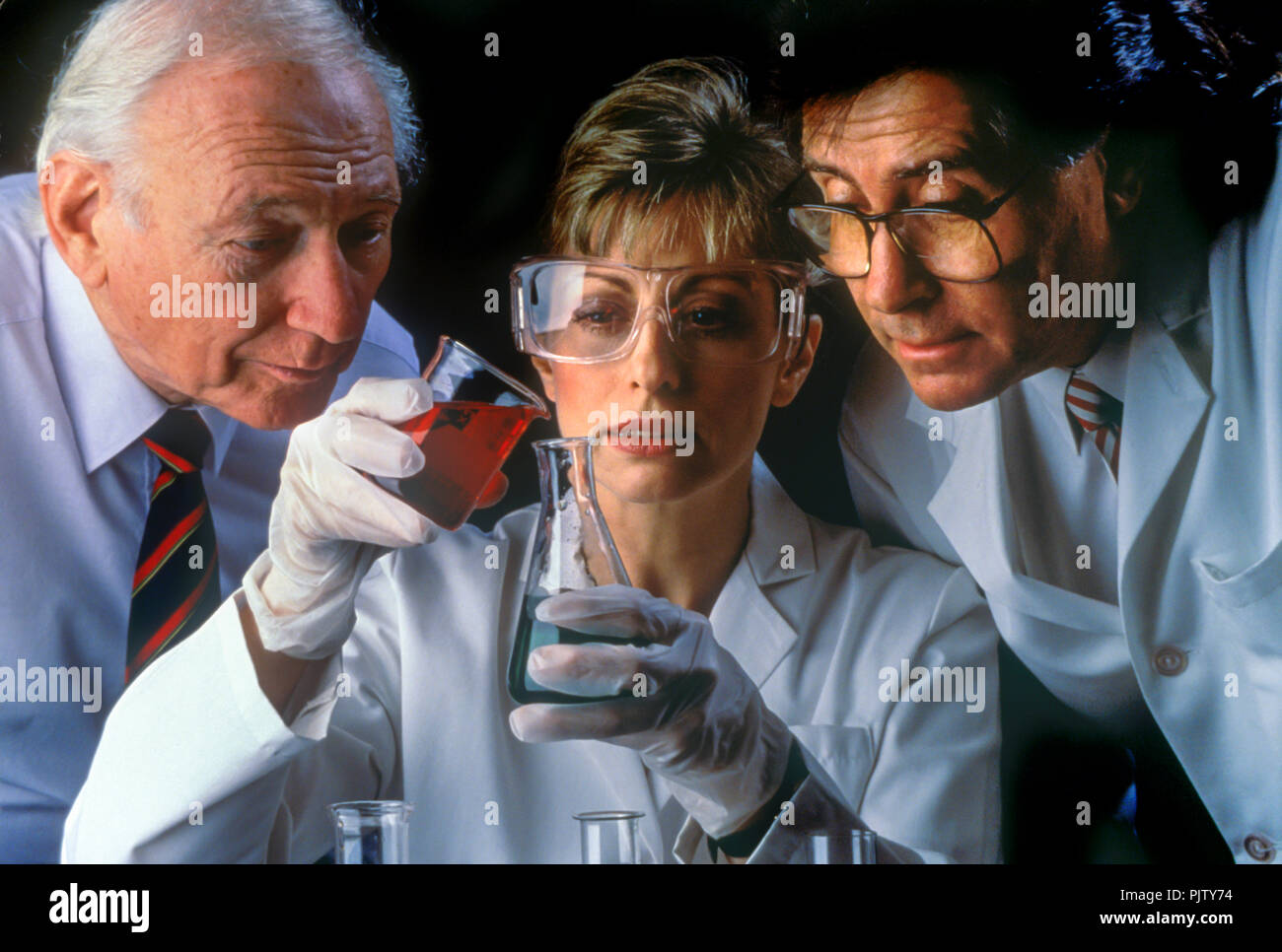 1990 HISTORISCHE GESICHTER VON CHEMIKERN IM LABOR, DIE CHEMISCHE REAKTIONEN BEOBACHTEN Stockfoto