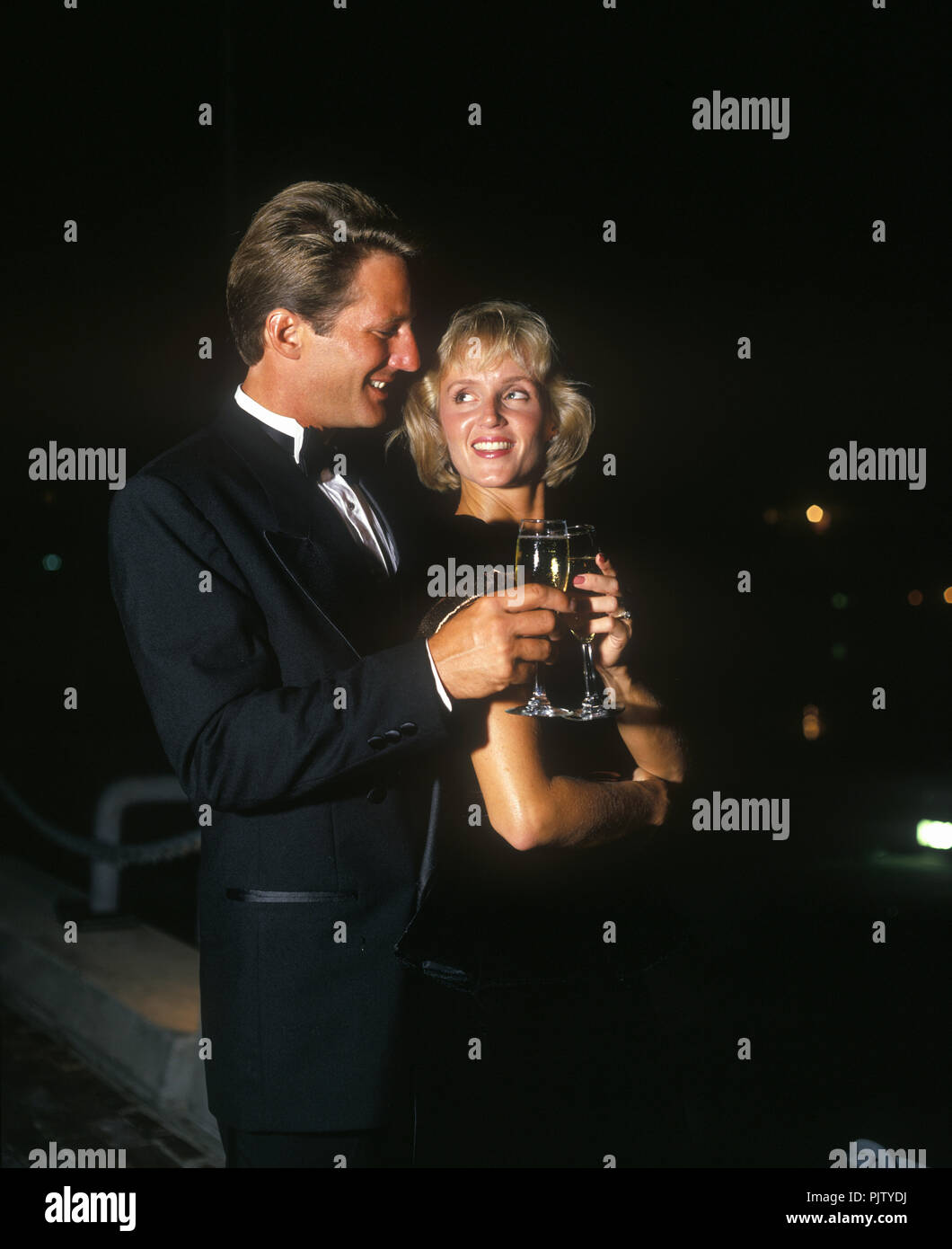 1990 historische PAAR ÜBER 21 JAHRE IN DEN ABEND trinken Champagner Stockfoto