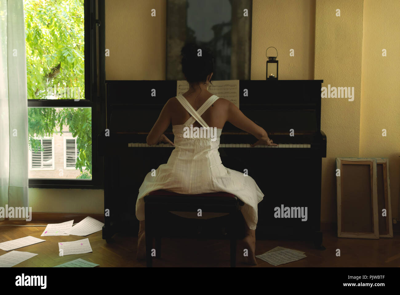 Frau in weißem Kleid Klavier spielen Stockfoto