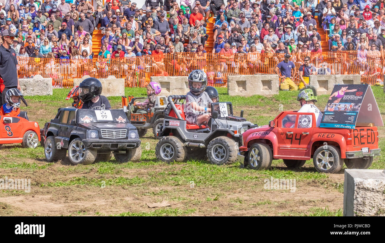 Kinder nehmen in einer Junior Demolition Derby an einem lokalen Herbstmesse mit batteriebetriebenen Mini Autos. Stockfoto
