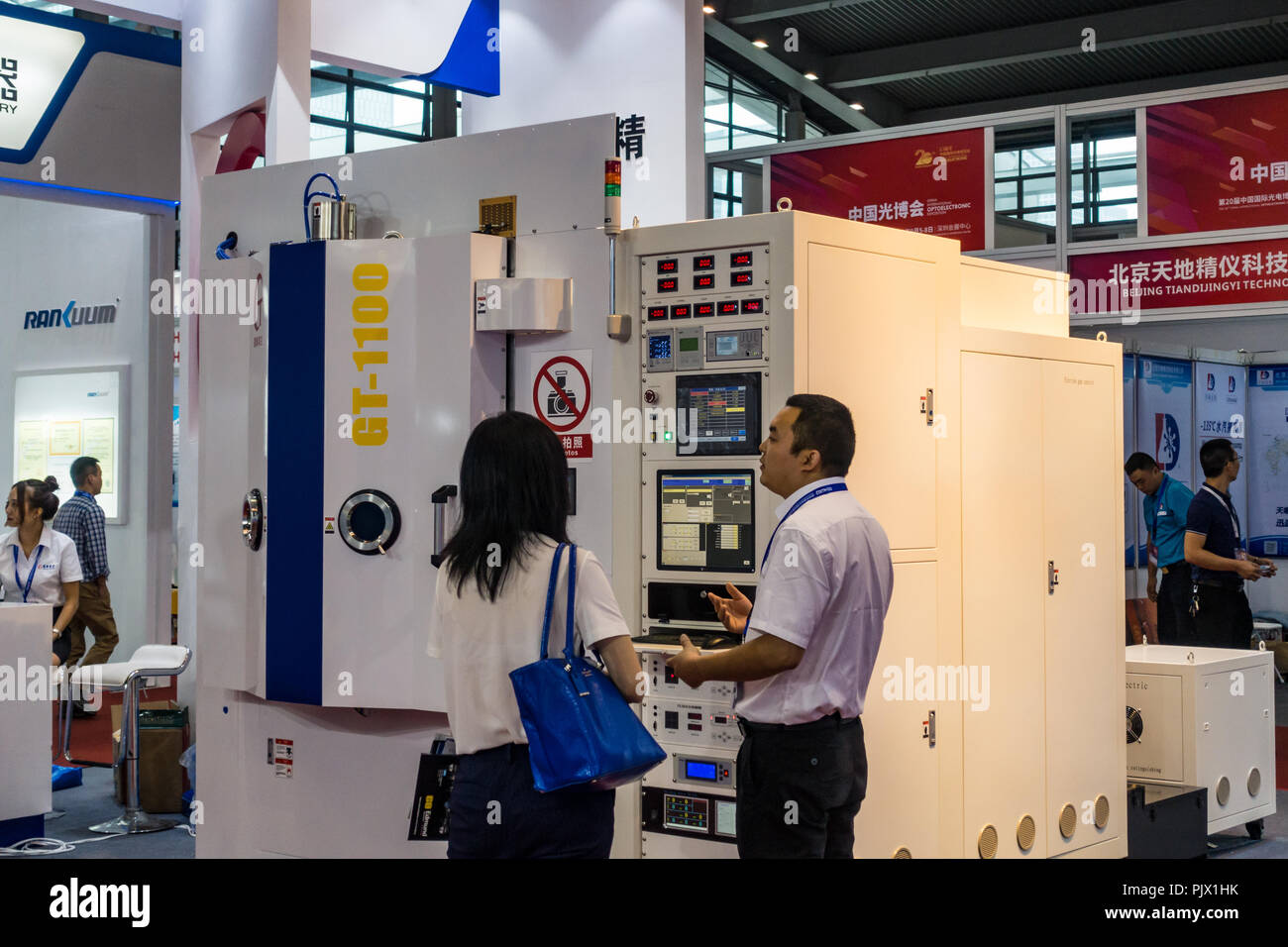 Chinesische Verkäufer Gespräche mit potenziellen Kunden in China Optoelectronics Expo in Shenzhen, China. Stockfoto