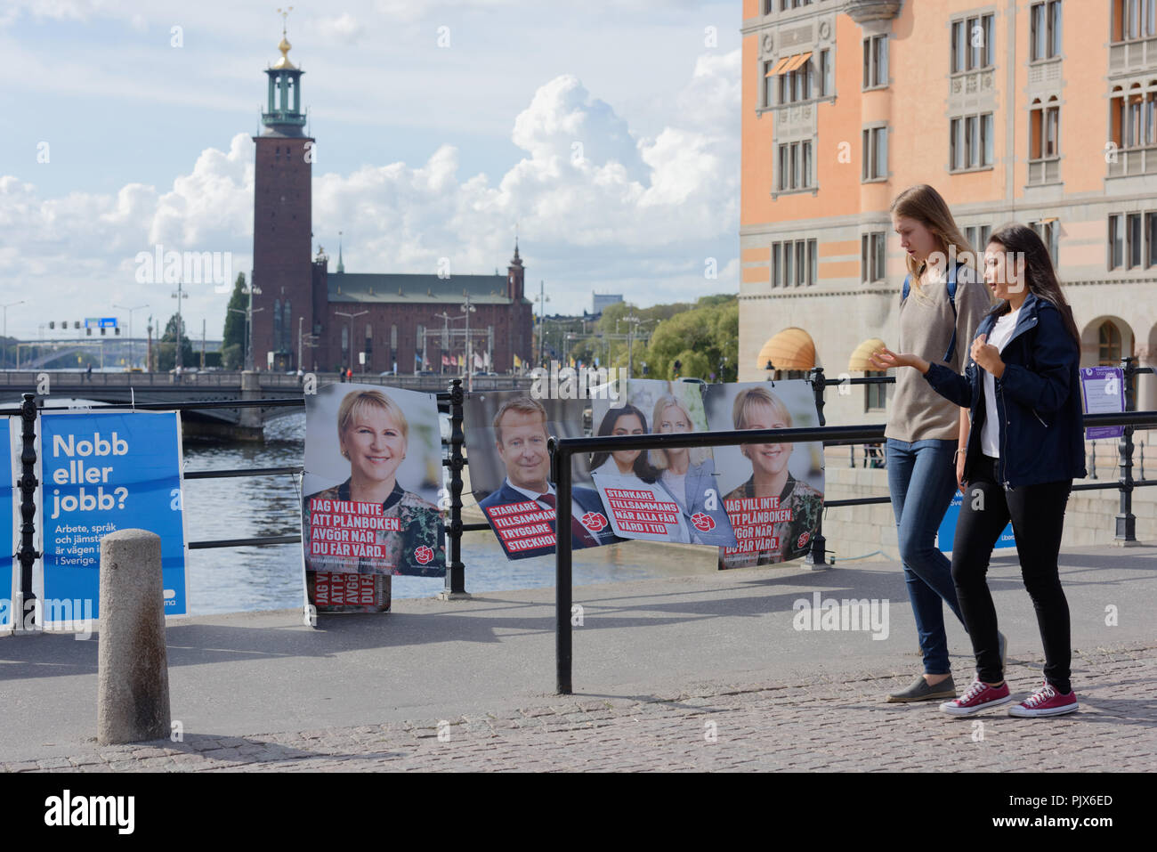 Stockholm, Schweden, 9. September, 2018. Leute, die durch die Banner der Kandidaten während der schwedischen Parlamentswahl 2018. An diesem Tag die Mitglieder des Reichstags gewählt werden, und die regionalen und kommunalen Wahlen sind noch am gleichen Tag Kredit: StockphotoVideo/Alamy Leben Nachrichten gehalten Stockfoto