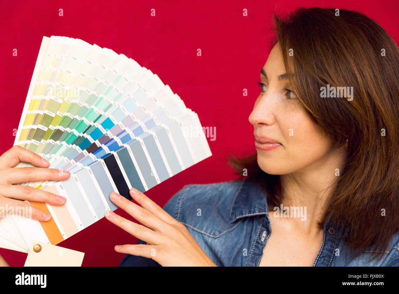 Home Improvement. Schöne Frauen wählen eine Farbe aus der Farbpalette. Ein Zimmer renovieren. Stockfoto