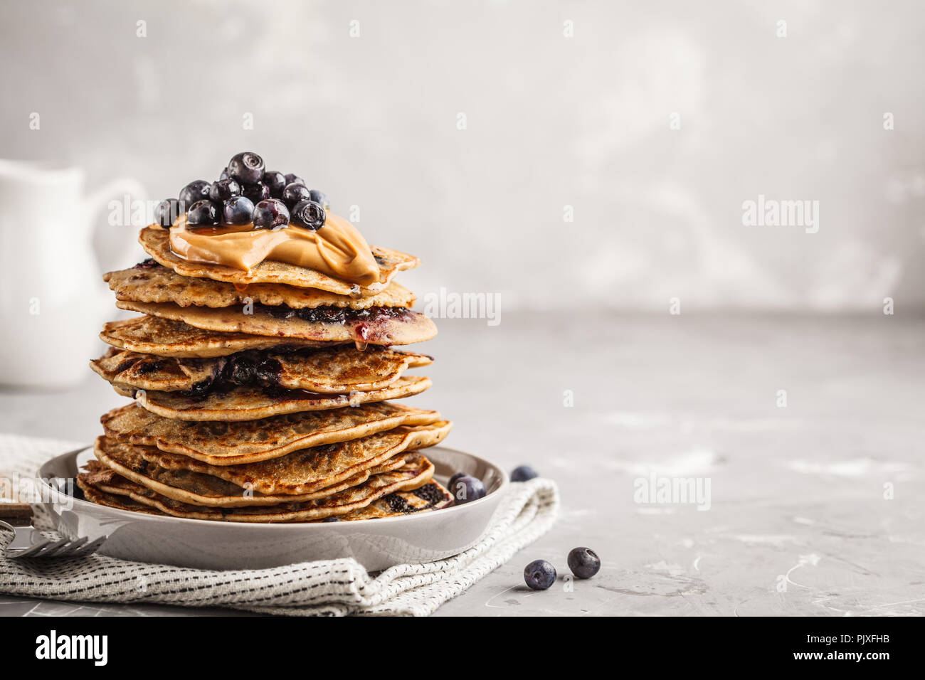Stapel vegan Blueberry Pancakes mit Erdnussbutter und Sirup. Saubere Konzept essen. Stockfoto
