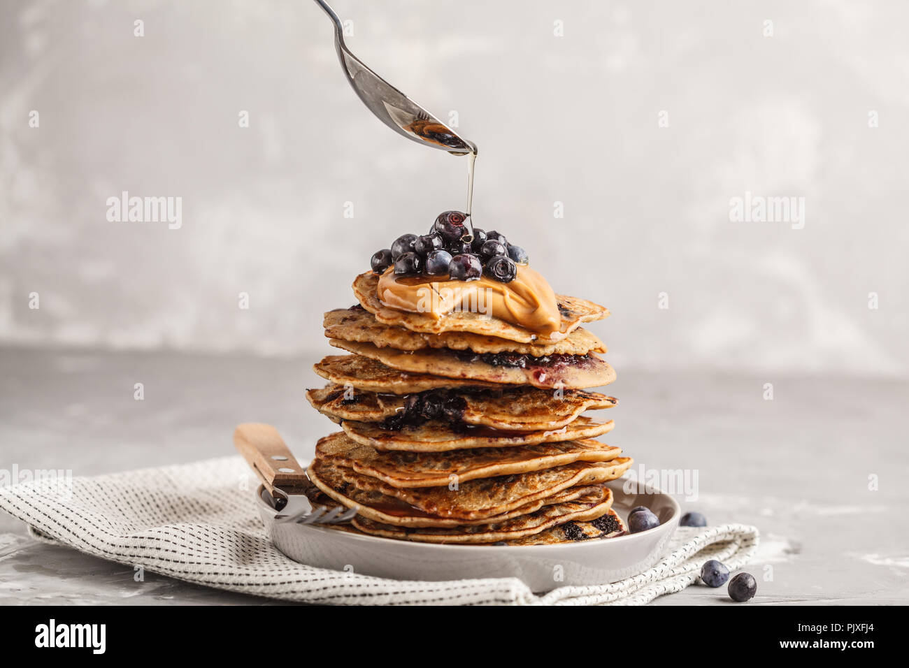 Stapel vegan Blueberry Pancakes mit Erdnussbutter und Sirup. Saubere Konzept essen. Stockfoto
