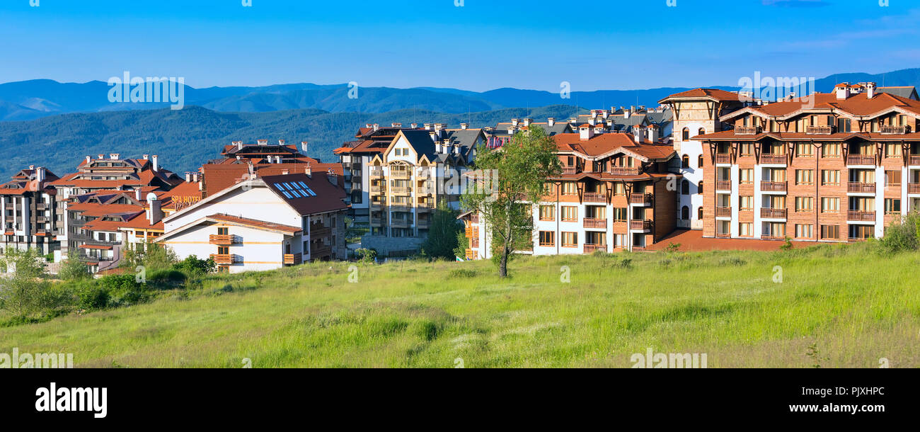 Bansko, Bulgarien - 13. Juni 2017: Chalet Hotel Häuser und Sommer Berge Panorama Banner in der bulgarischen all season Resort Stockfoto