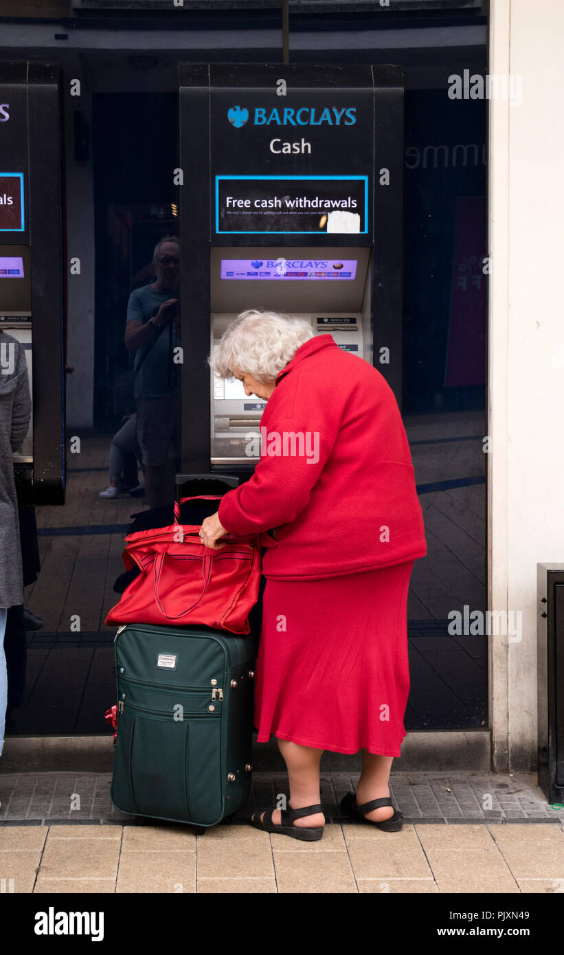 Ältere Dame mit einem Barclays Bank, Geldautomat, Bristol, England, Großbritannien Stockfoto