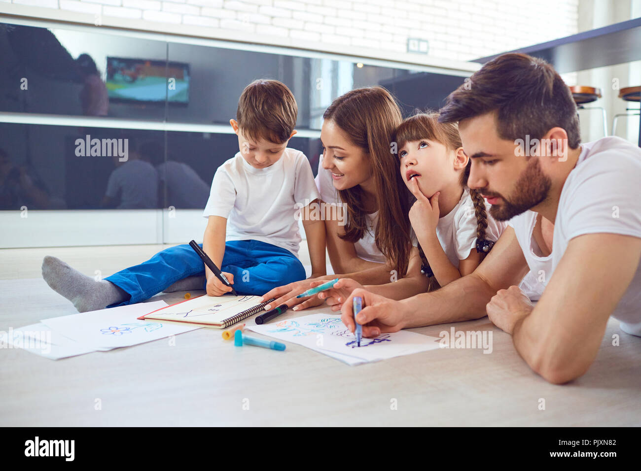 Eine Familie zieht auf dem Papier liegen auf ihre freie Zeit auf dem Boden. Stockfoto