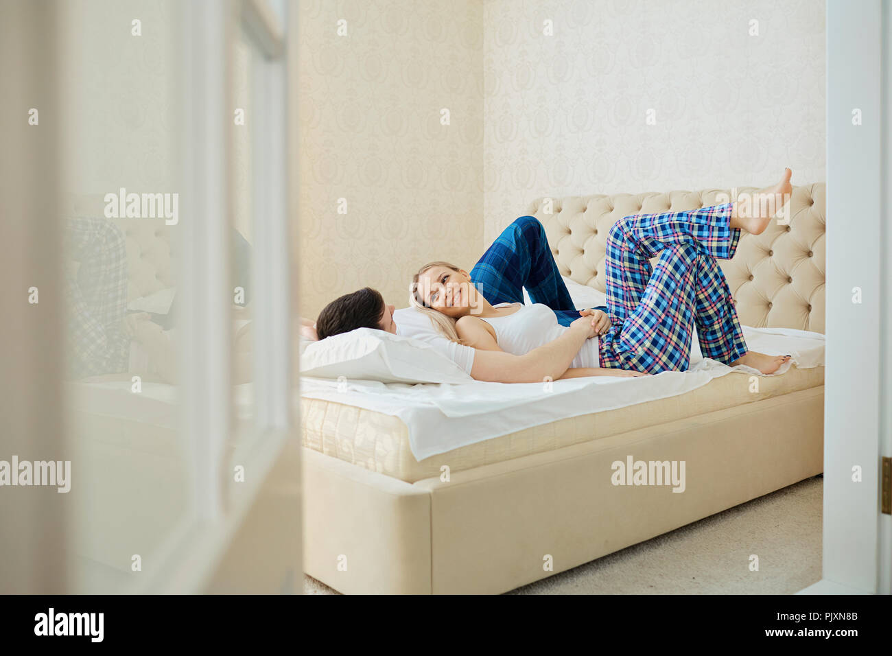 Paar im Bett Schmusen im Schlafzimmer. Stockfoto