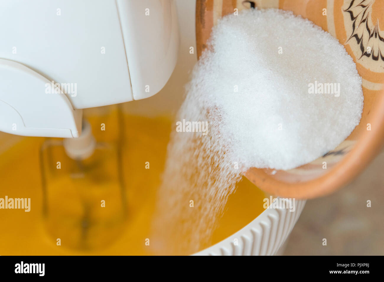 Mixer peitsche Eigelb mit Zucker - close-up. Mixer Quirl Eier und Zucker Stockfoto