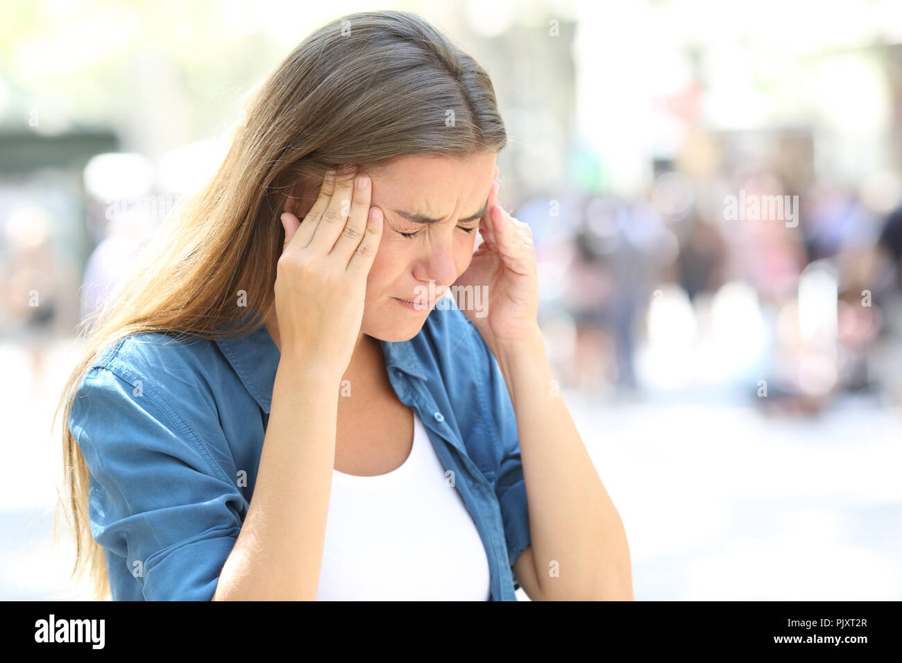 Schmerzhafte Mädchen leiden Migräne berühren Tempel auf der Straße Stockfoto