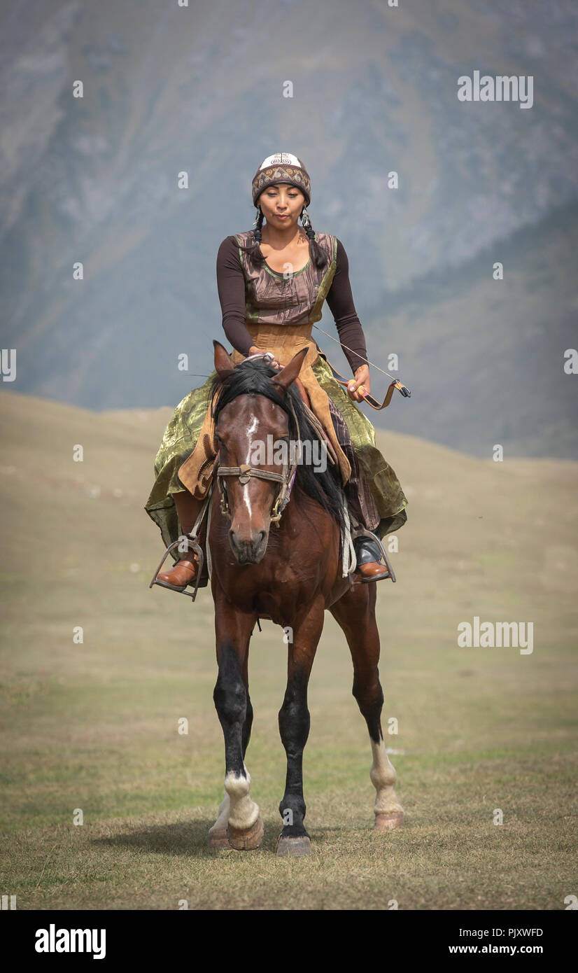 See Issyk-Kul, Kurgyzstan, 6. September 2018: nomad Lady mit einem Bogen und Pfeile auf dem Pferd in der Natur Stockfoto