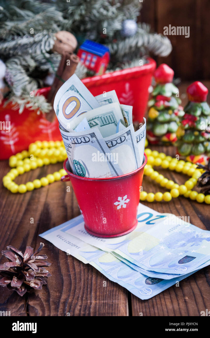 Twisted Rechnungen von Dollar und Euro in Red christmas Schaufel, Euro und Rosa Makronen. Geschenke des Neuen Jahres Stockfoto