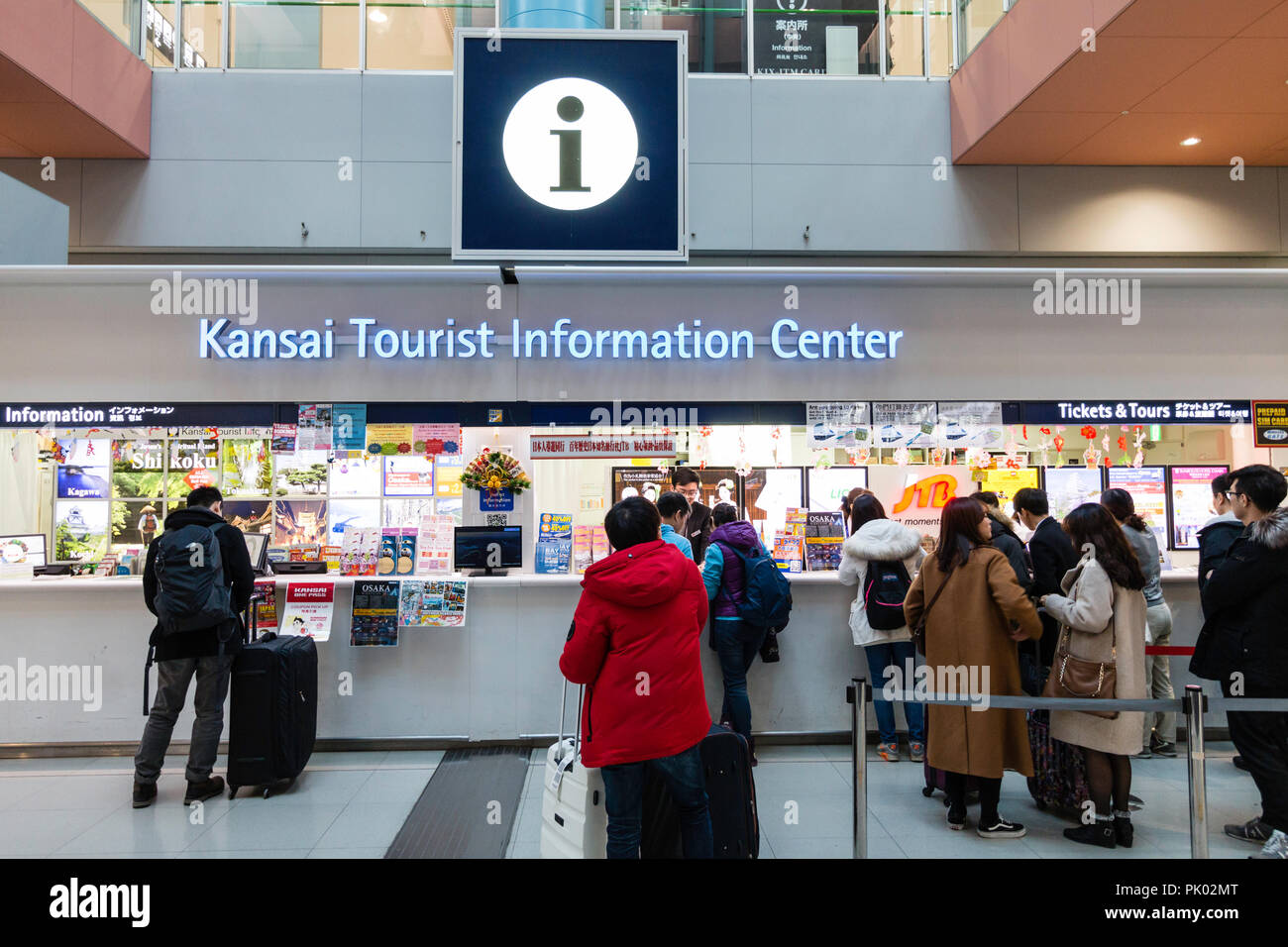 Japan, Osaka. Kansai International Airport. KIX, Terminal 1, Erdgeschoss Touristeninformation mit Menschen warten. Stockfoto