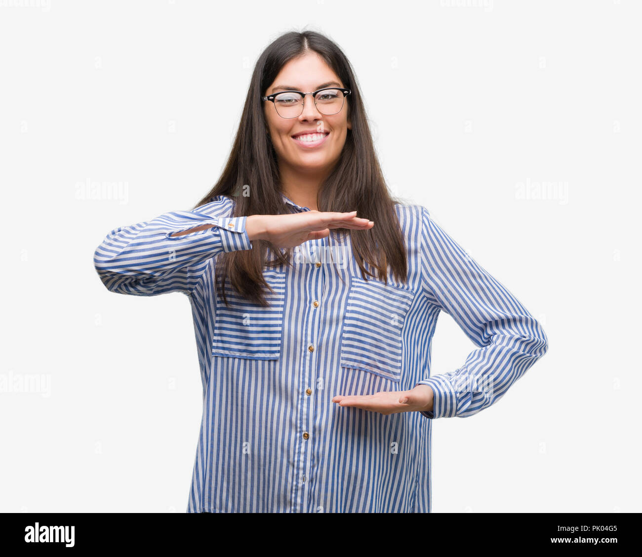 Junge schöne Hispanic Business woman gestikulierte mit Händen zeigen große und große Zeichen, Symbol. Lächelnd in die Kamera schaut. Messung Stockfoto