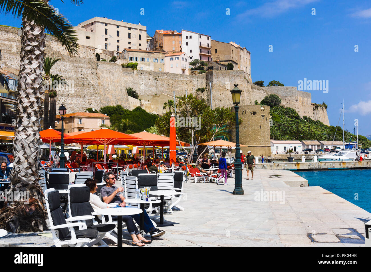 Restaurants am Wasser, Zitadelle im Hintergrund. Calvi, Korsika, Frankreich Stockfoto