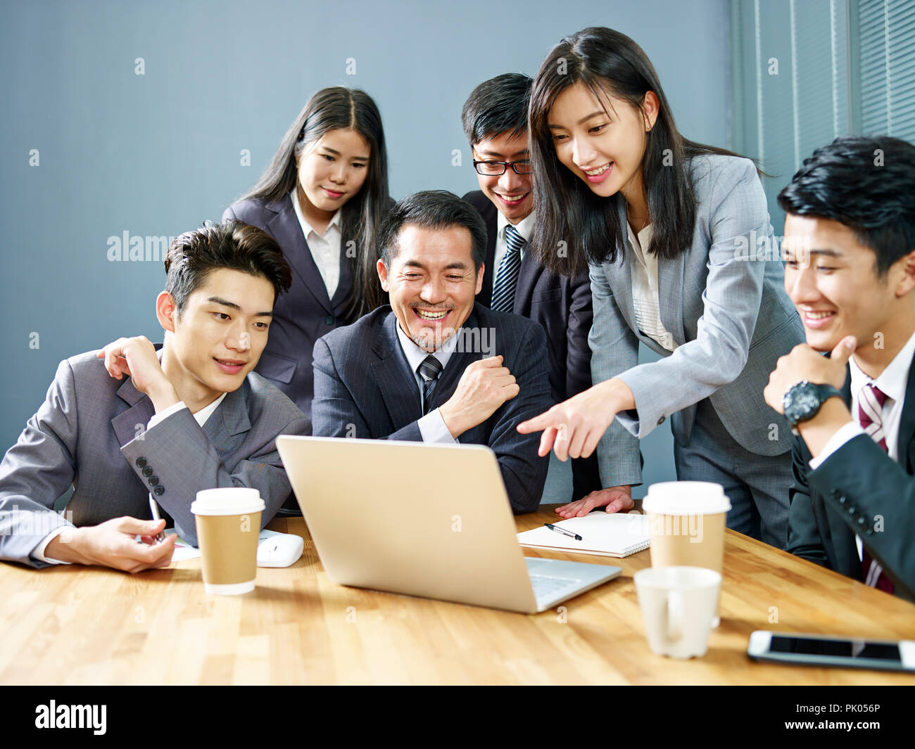Ein Team von asiatischen Führungskräfte mit Laptop arbeiten zusammen im Büro, glücklich und lächelnd. Stockfoto