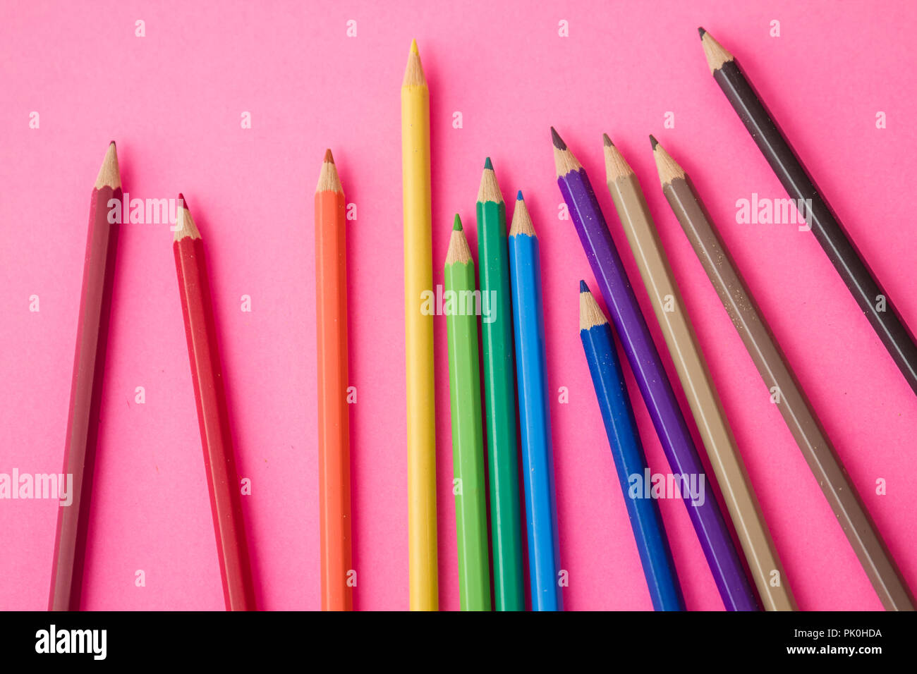 Bündel Bunte Bleistifte auf rosa Hintergrund verstreut Stockfoto