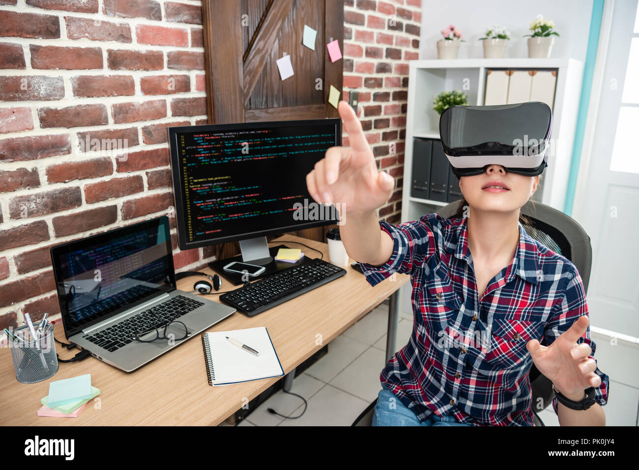Asiatische Frau tragen Virtuelle Realität und Arm berühren im Studio. Stockfoto