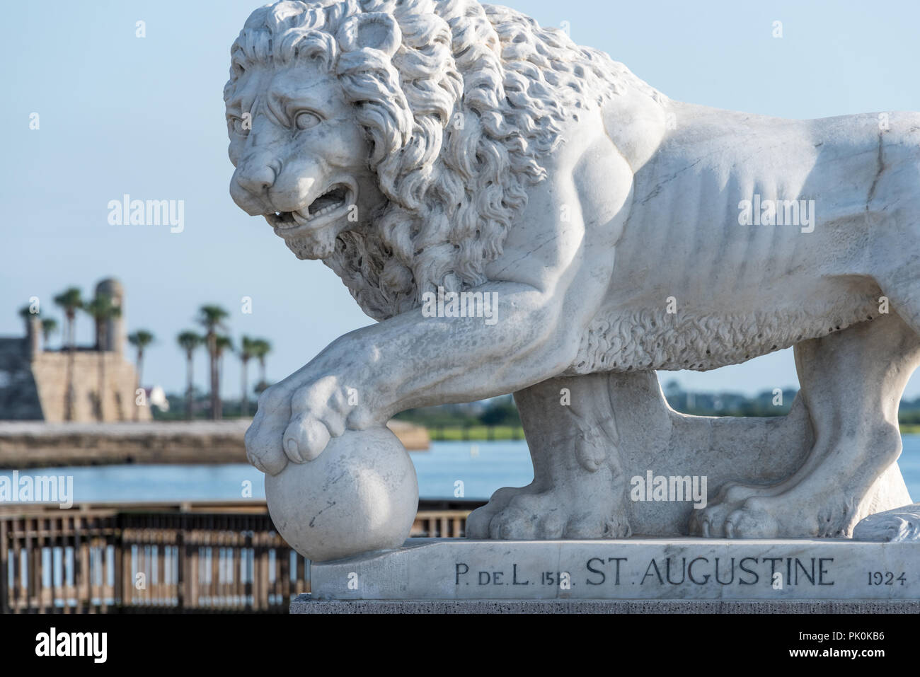 Aus weißem Carrara-Marmor lion Statue auf St. Augustine, Florida's Bridge of Lions über Matanzas Bay, mit dem Castillo de San Marcos fort im Hintergrund. (USA) Stockfoto