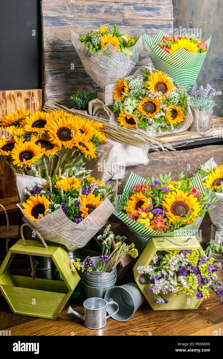 Arbeitsplatz Florist. Schönen Blumensträußen mit Sonnenblumen auf einem Holztisch. Vertikaler Stockfoto