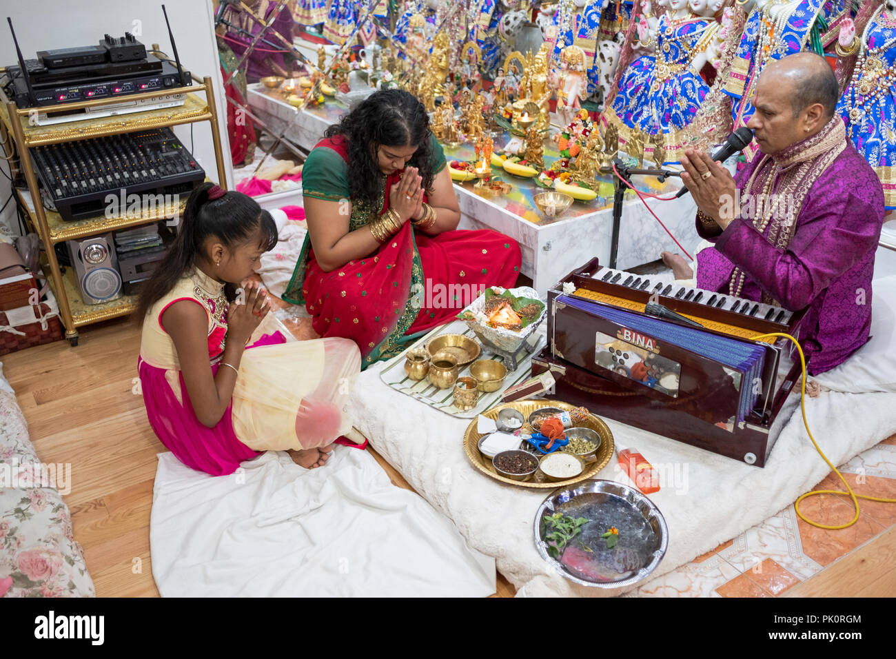 Ein Hindu pandit Durchführung ein Gebet Service in einem kleinen Tempel im Keller seines Hauses in South Richmond Hill, Queens, New York. Stockfoto