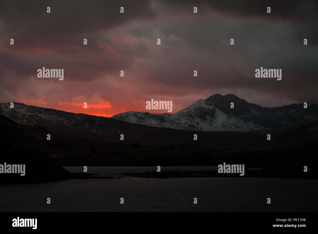 Llyn Mymbyr und Snowdon im Winter unter stürmischen Himmel bei Sonnenuntergang, Snowdonia, North Wales Stockfoto
