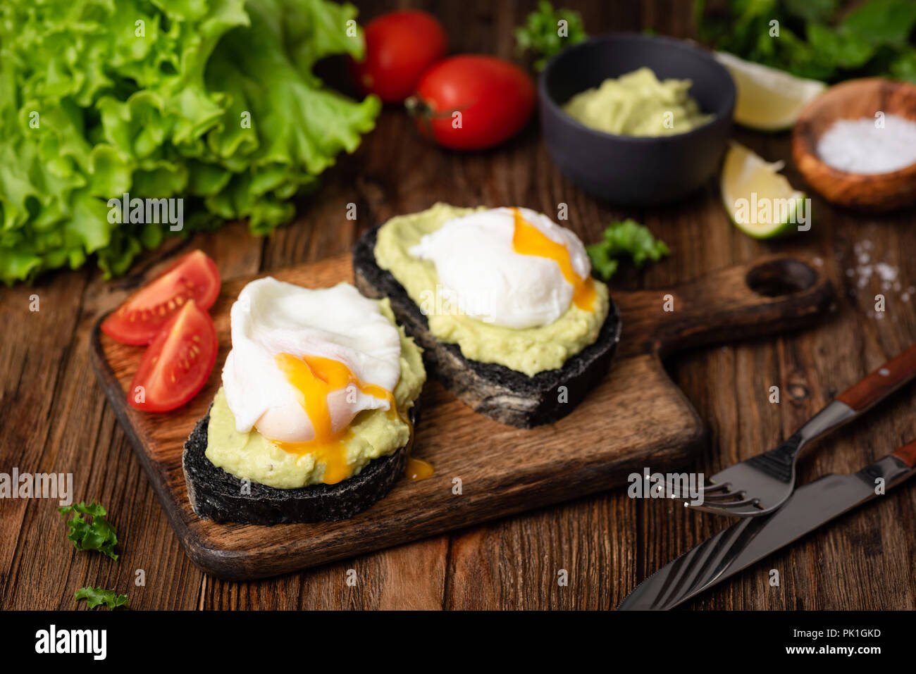 Gesunde leckere Toast mit Avocado pochiertes Ei auf Holz serviert. Detailansicht, selektiver Fokus Stockfoto