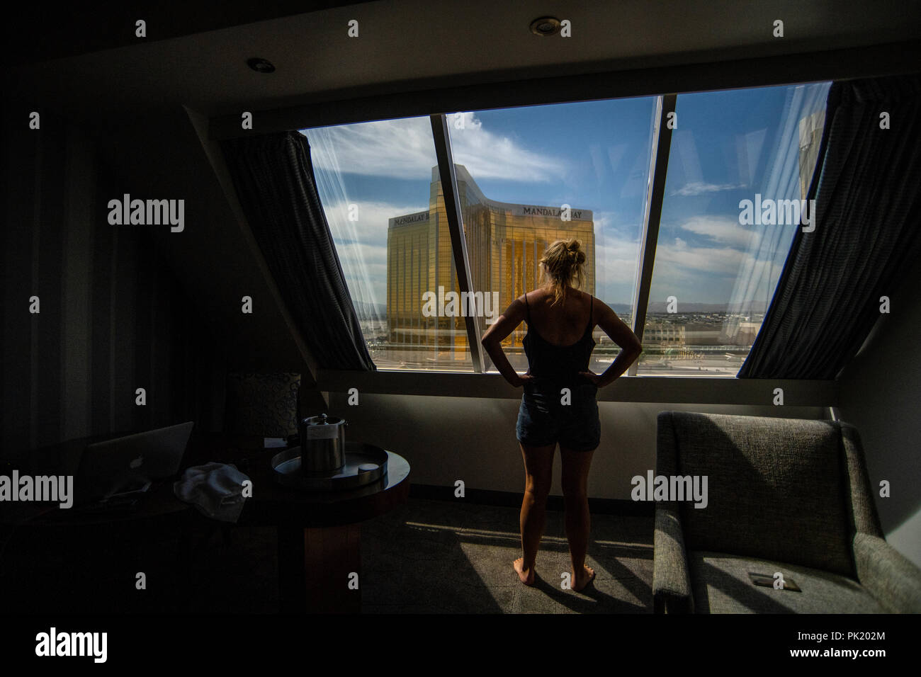 Eine Frau schaut aus einem Hotel Zimmer im Luxor Hotel und Casino in Richtung Mandalay Bay und Delano Resorts in Las Vegas, Nevada, USA. Stockfoto