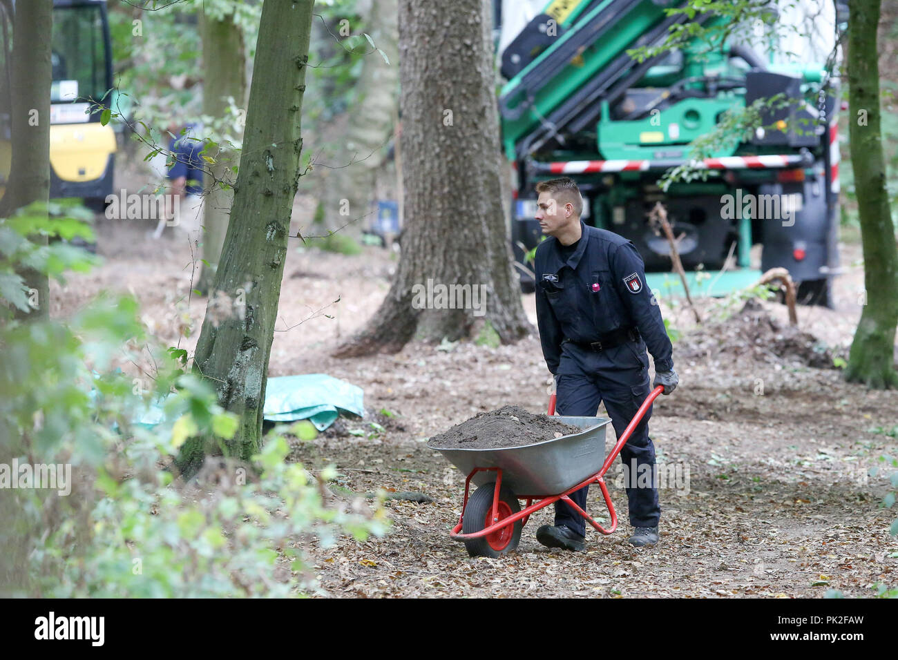 10.09.2018, Hamburg: ein Polizist schiebt die Schubkarre mit der Erde bei der Suche nach der fehlenden Hilal im Altonaer Volkspark. Mehr als 19 Jahre nach dem Verschwinden des Mädchens Hilal, die Hamburger Polizei hat eine Leiche Suche im Altonaer Volkspark begonnen. Foto: Bodo Marks/dpa Stockfoto