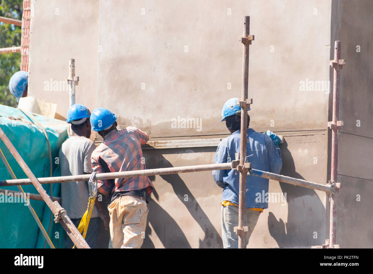 Eine Nahaufnahme der Arbeitnehmer auf einer Baustelle auf dem Gerüst stehend Verputzen eine neue Wand Stockfoto