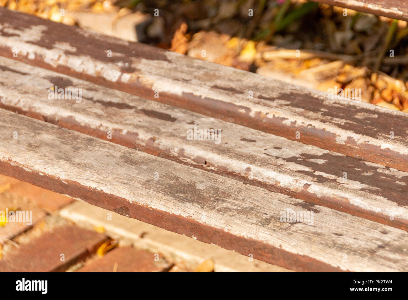 Eine Nahaufnahme eines warnen alten Doppel sitzen im freien Stuhl mit Holz- Schiefer und konkrete Seiten auf Pflastersteine in einem Park Stockfoto