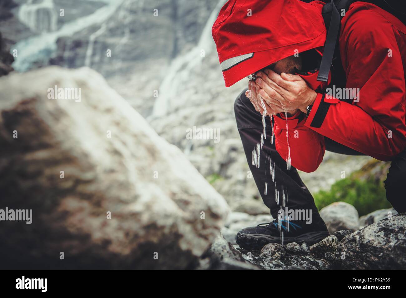 Trinkwasser in der Wildnis. Kaukasische Wanderer Trinken frisches Wasser direkt aus Mountain River. Stockfoto