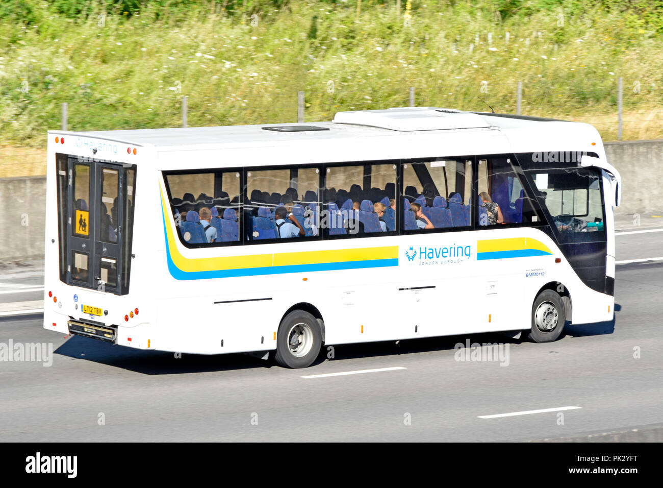 Transport im Schulbus mit voller Ladung von Kindern in Uniform auf Bildungsreise, durchgeführt vom Havering council, auf der Autobahn M25 Essex UK Stockfoto