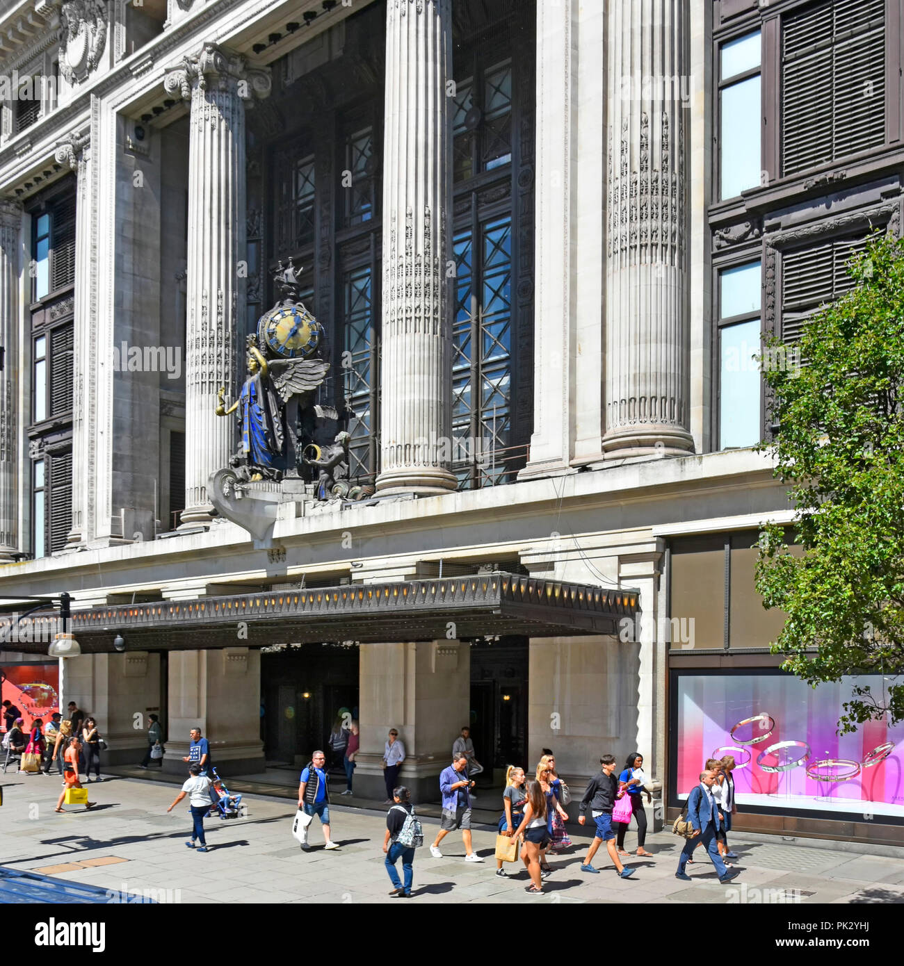 Shopper in London Shopping Street Szene vor der Außenfassade und Skulptur im Selfridges Oxford Street Kaufhaus West End Mayfair UK Stockfoto
