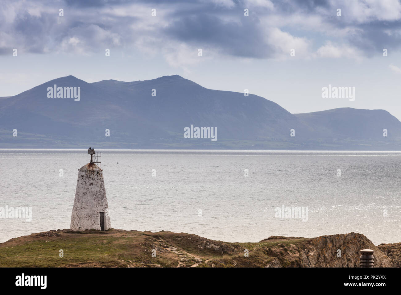 Twr Bach Leuchtturm, Anglesey, Wales UK, mit den Bergen von Snowdonia National Park in der Ferne Stockfoto