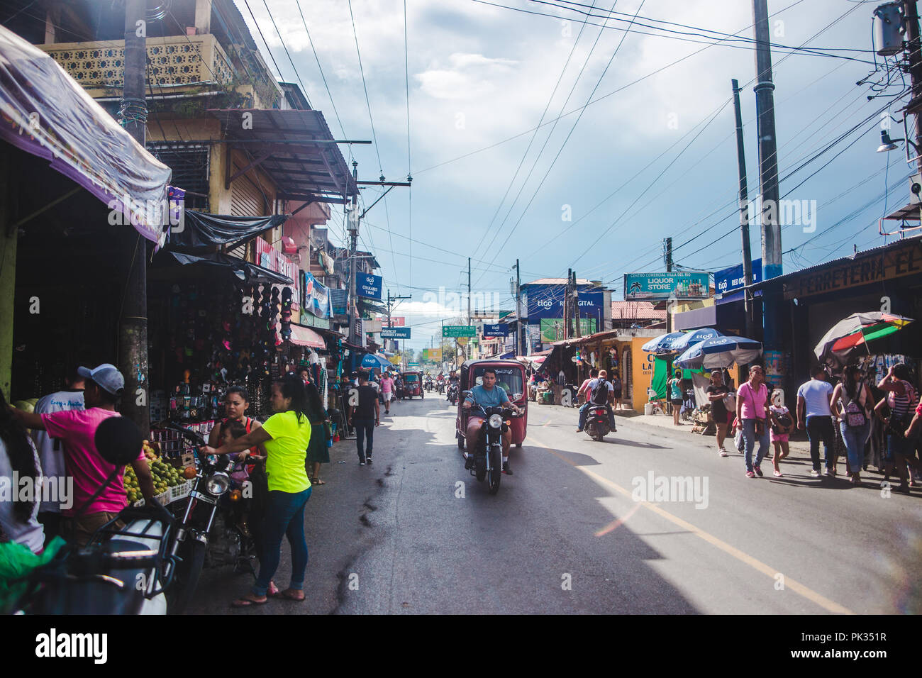 Geschäftige Straßen mit der Familie unternehmen gefüttert und mit tuktuks in Rio Dulce, einer kleinen Stadt im Osten Guatemalas gefüllt Stockfoto