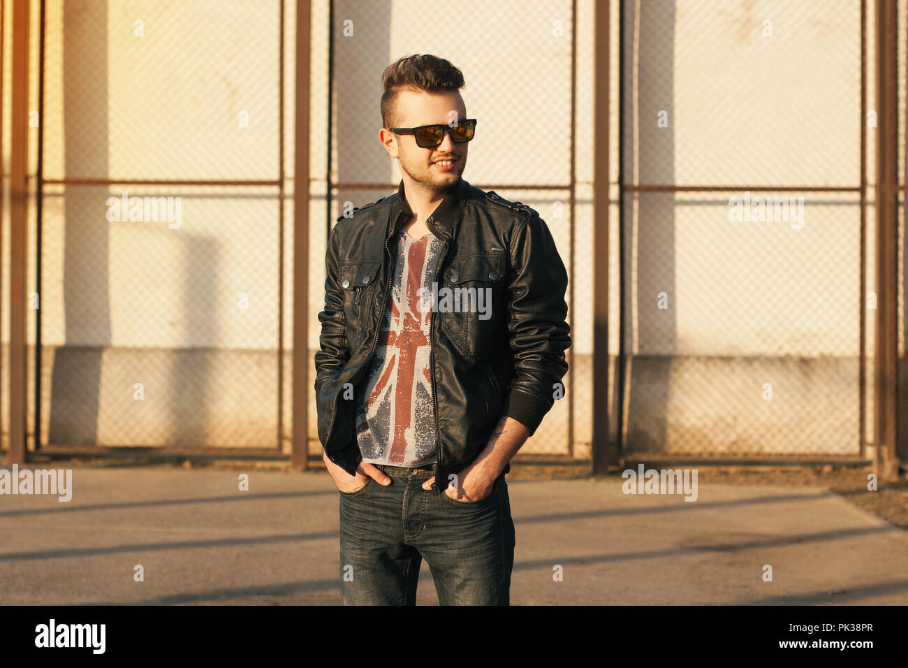 Hipster in eine schwarze Lederjacke und Sonnenbrille. Im freien Sonnenuntergang Porträt. Stockfoto