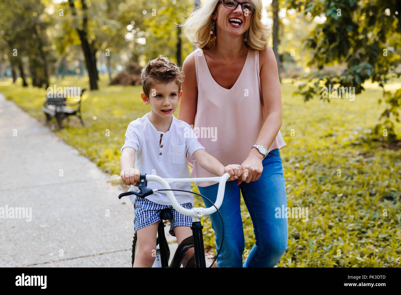 Mutter mit ihrem Sohn ein Fahrrad fahren lernen Stockfoto