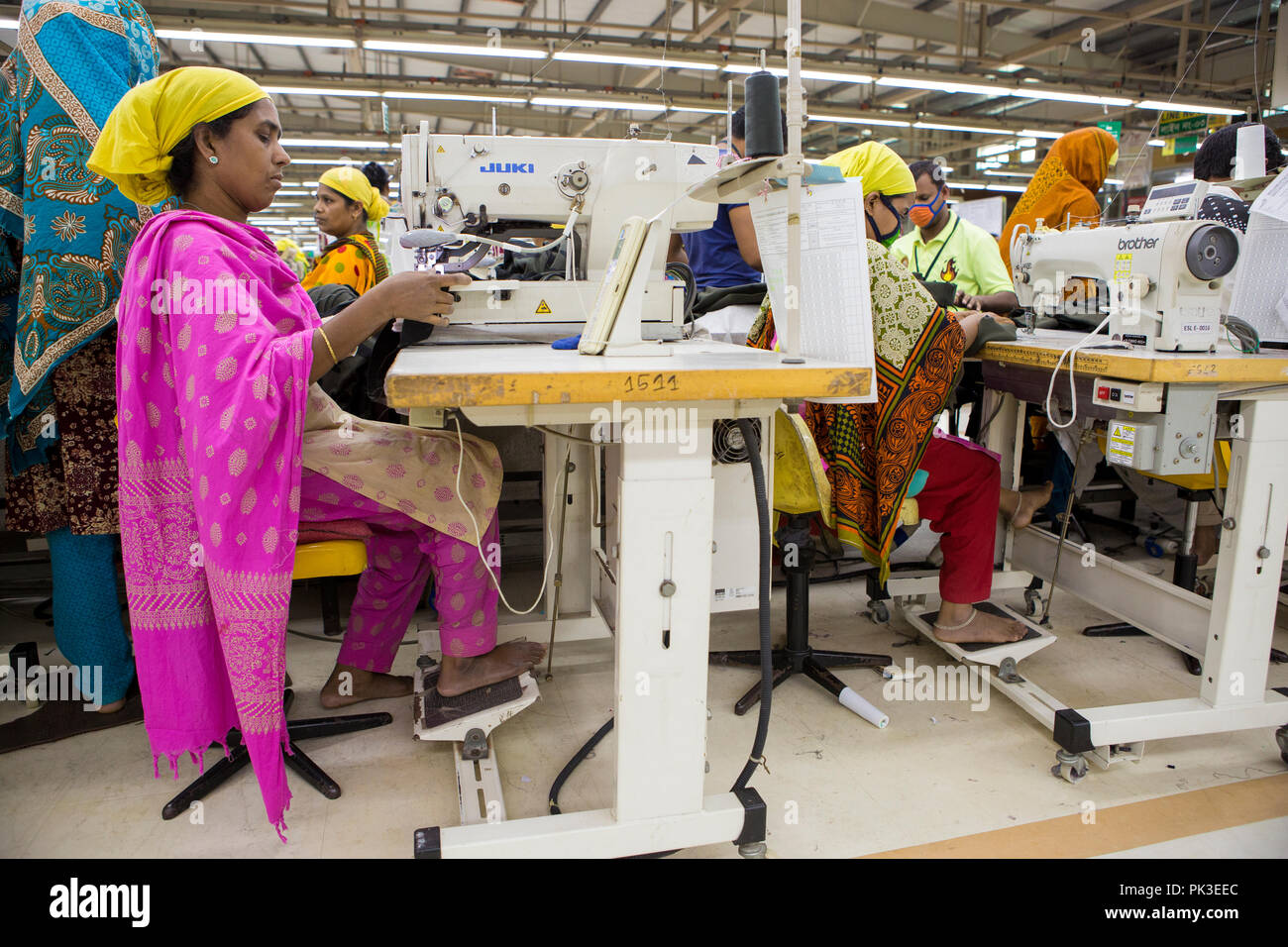 Eine Näherin bei der Arbeit an der Nähmaschine in einer Textilfabrik in Bangladesch. Stockfoto