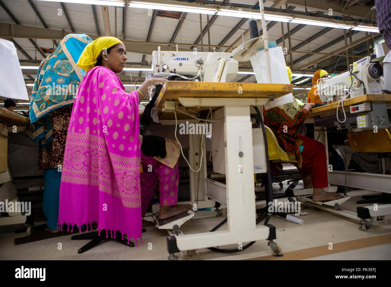 Eine Näherin bei der Arbeit an der Nähmaschine in einer Textilfabrik in Bangladesch. Stockfoto