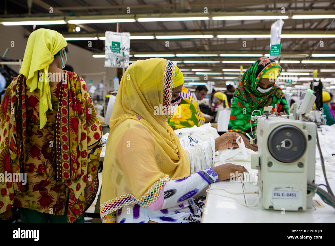Eine Frau auf einer Nähmaschine zu einer Textilfabrik in Dhaka, Bangladesh. Stockfoto