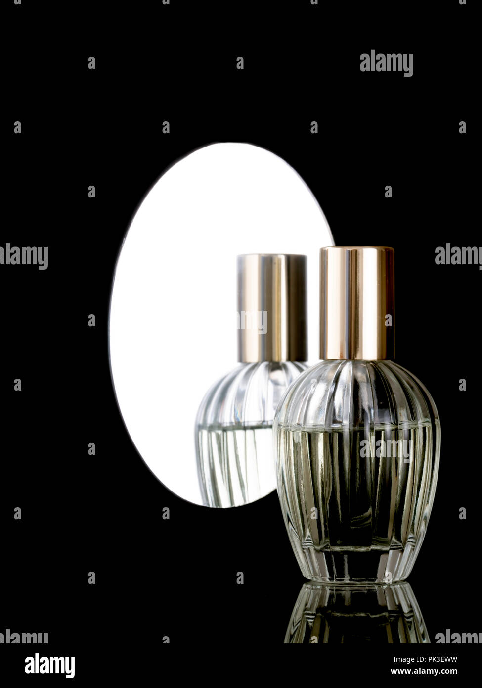 Elegante Klarglas Parfüm Flasche auf einem glänzenden, schwarzen Hintergrund mit Reflexion auch im Spiegel hinter sich. Mit Copyspace. Stockfoto