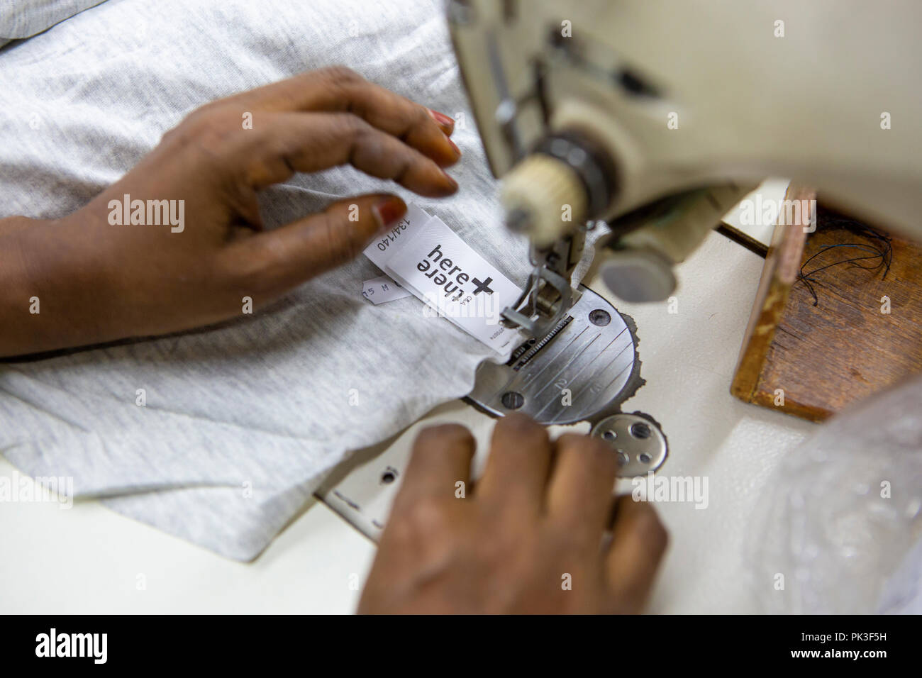 Ein Etikett in ein T-Shirt in einer Textilfabrik in Bangladesch genäht. Stockfoto
