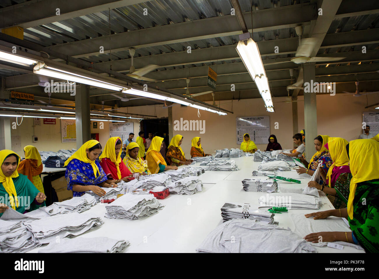 Eine Gruppe der weiblichen Textilarbeiterinnen Falten Kleidung in einer Textilfabrik in Bangladesch. Stockfoto