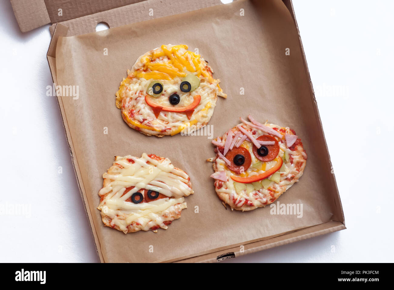 Halloween Pizza mit Monster, oben genannten Szene mit Dekor auf ein Handwerk Papier, Hintergrund, Idee für Home Party Essen, einfach, gesunde und köstliche Spaß Essen Stockfoto