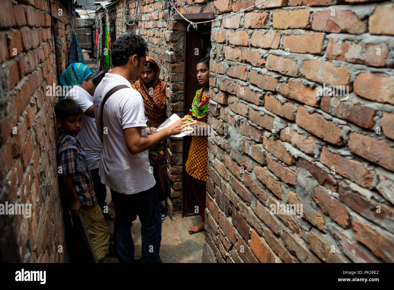 Community Bereich Personal im Gespräch mit Textilarbeiterinnen in den Slums, wo sie sich in Dhaka, Bangladesch leben. Stockfoto