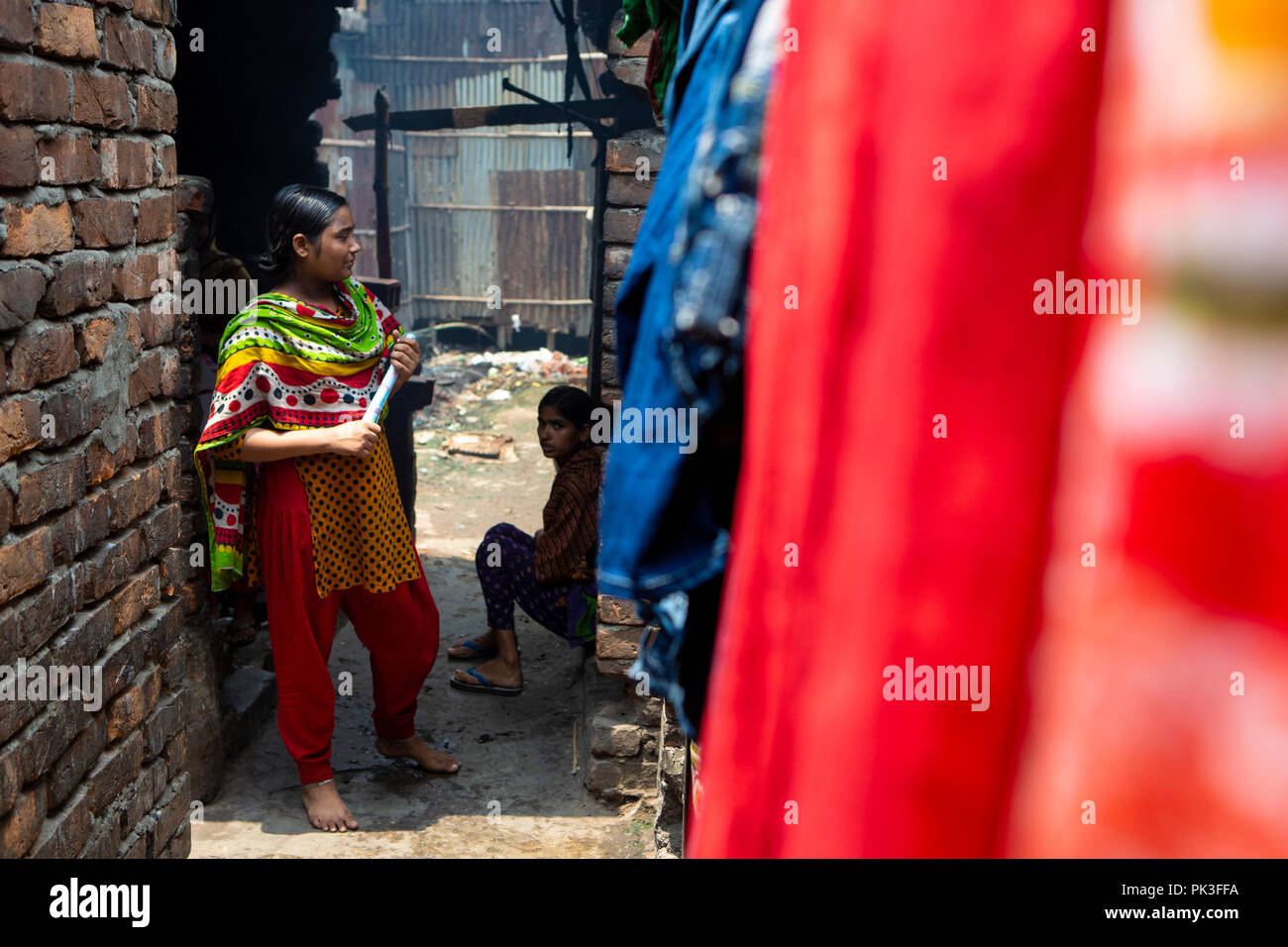 Eine Näherin, die eine aufgerollte Dokument außerhalb ihrer Heimat in Dhaka, Bangladesh. Stockfoto