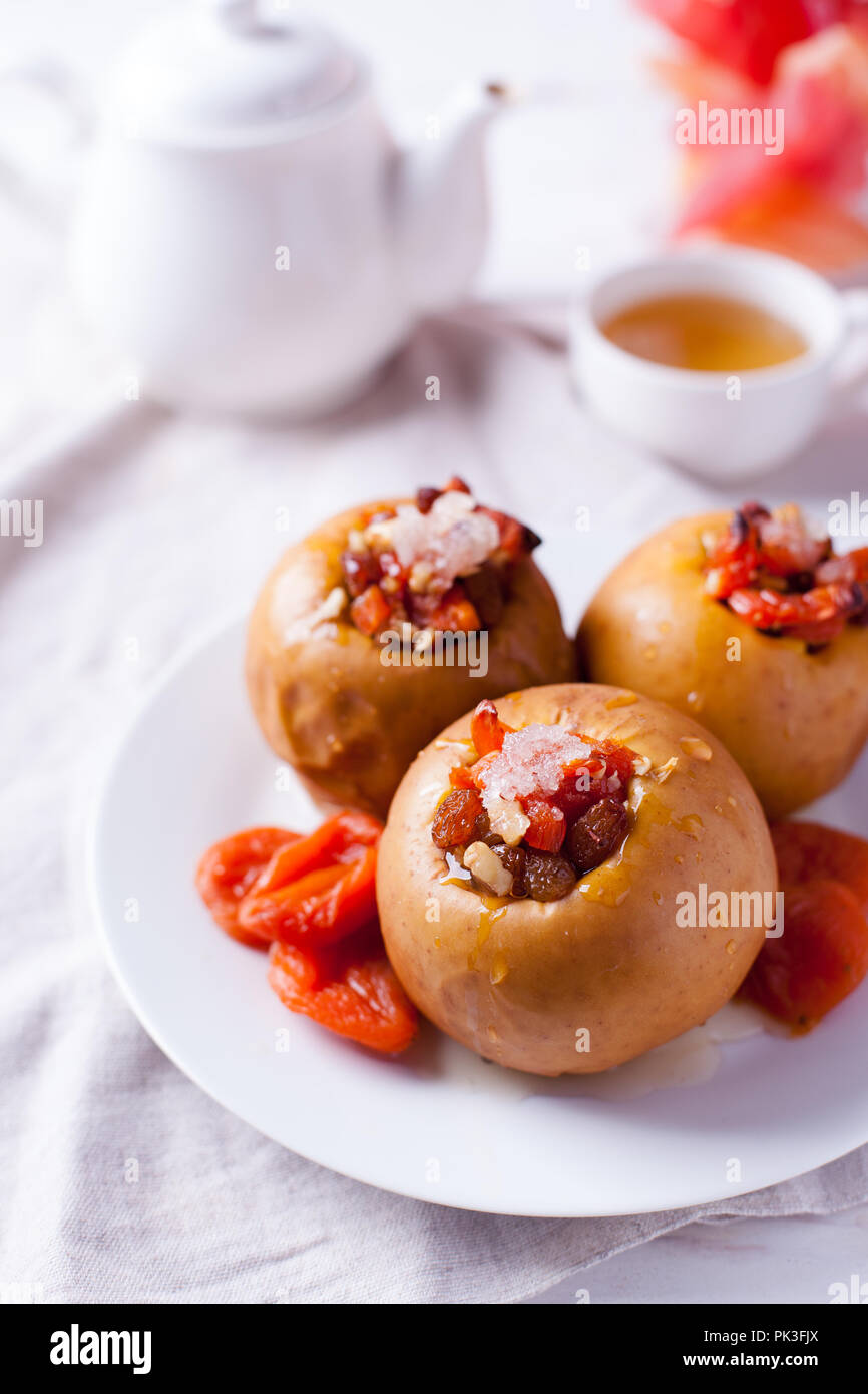 Gebackene Äpfel mit Zimt, Nüssen und Honig auf einem weißen Hintergrund. Herbst oder Winter Dessert Stockfoto